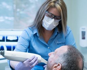 dental hygienist scanning male patient for invisalign with iTero